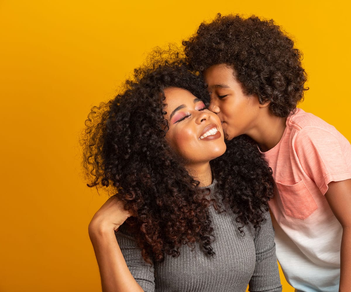 portrait-young-african-american-mother-with-toddler-son-son-kissing-his-mother-yellow-wall-brazilian-family